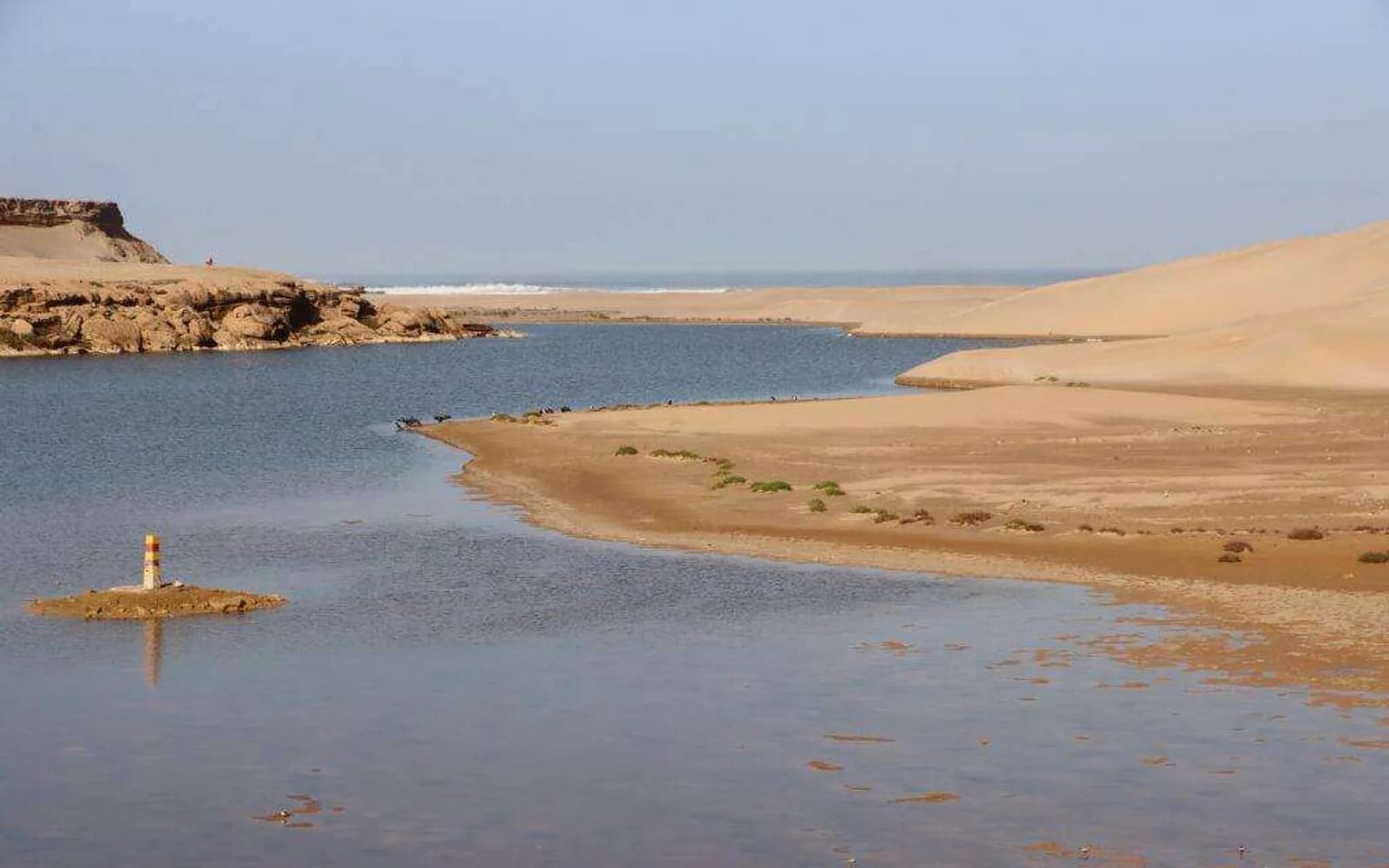Berges ocre et embouchure sableuse de l'Oued Chbika rejoignant l'Atlantique près d'El Ouatia
