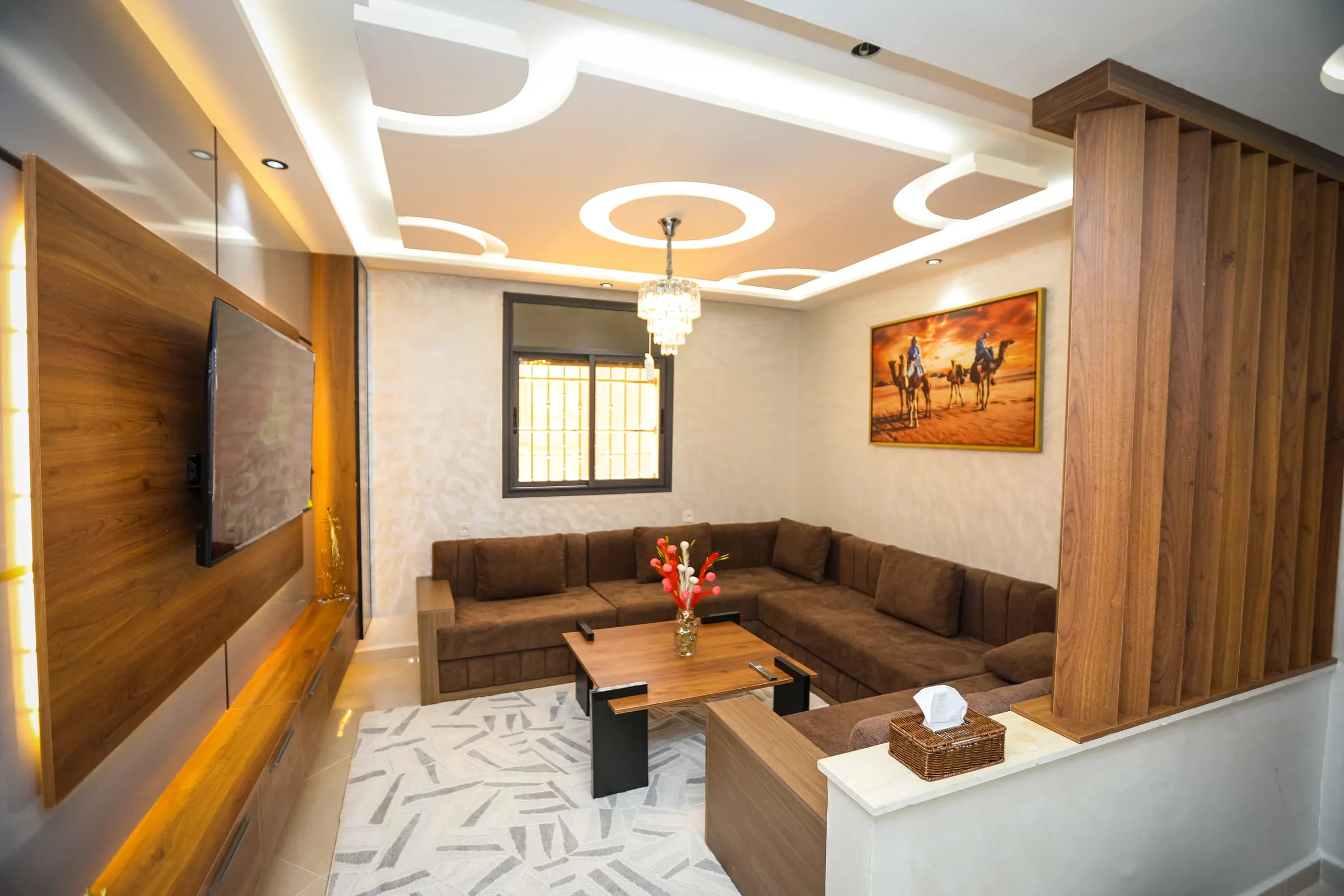 The warm living room of Résidence Acharif — corner sofas and walnut panelling